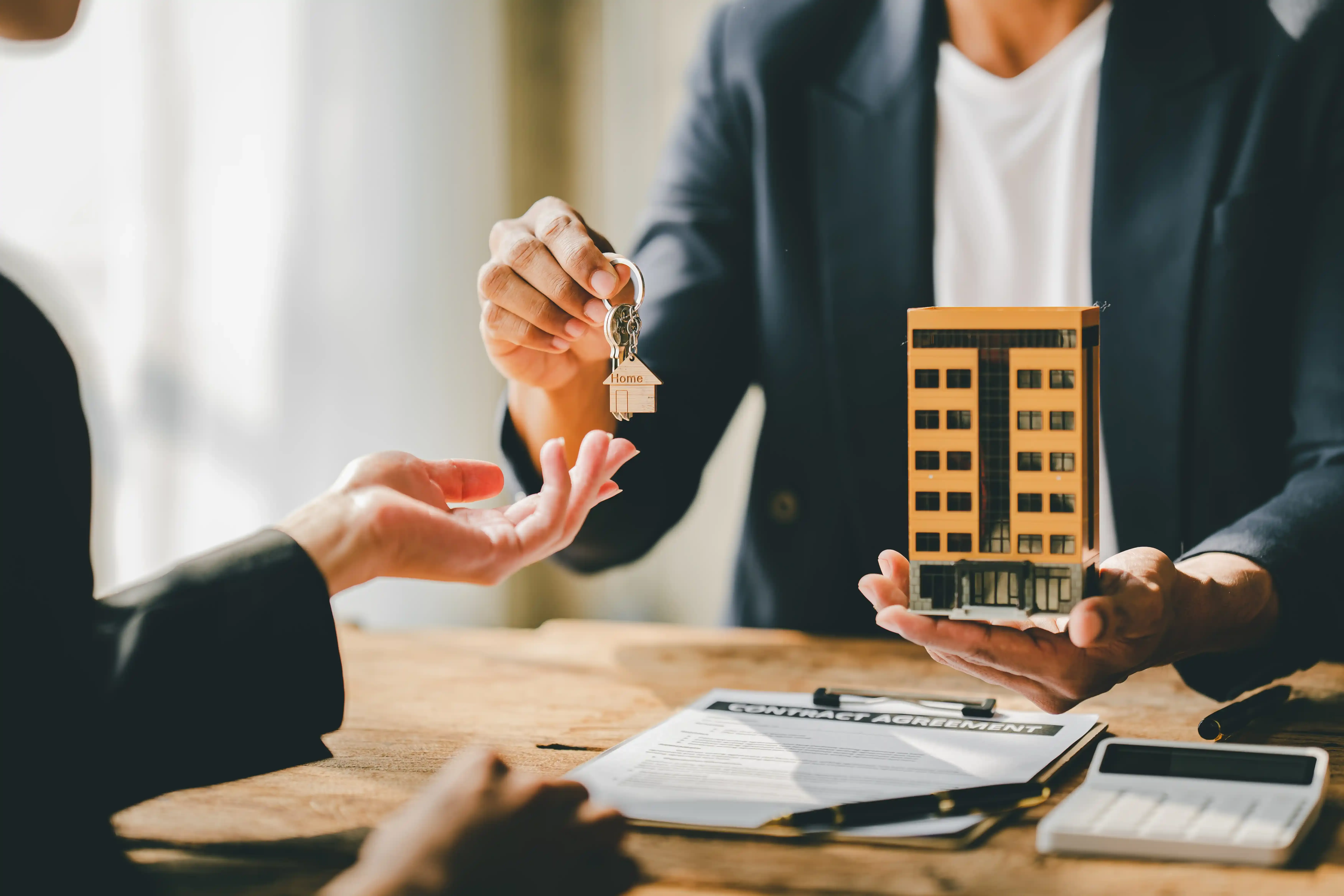 Imagen de un asesor otorgando las llaves de el departamento o casa